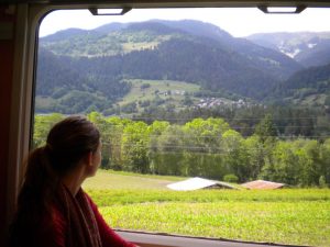Caitie looks at the window of a speeding Swiss train