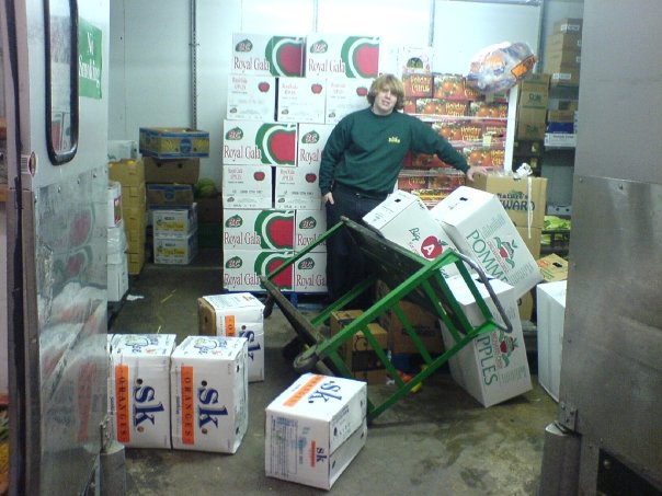 Steven stands surrounded by a mess of boxes