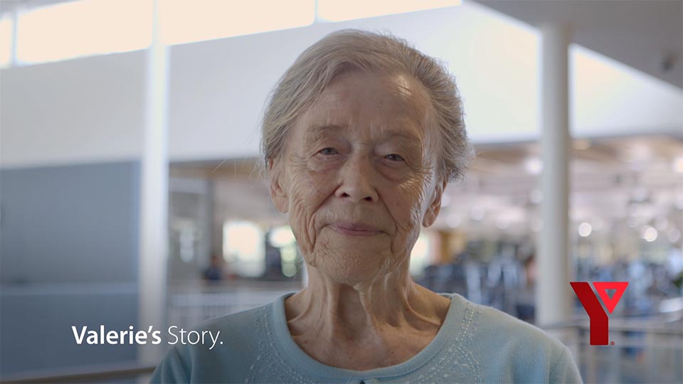Valerie, a 90-year old YMCA member looks directly into the camera with a smile.