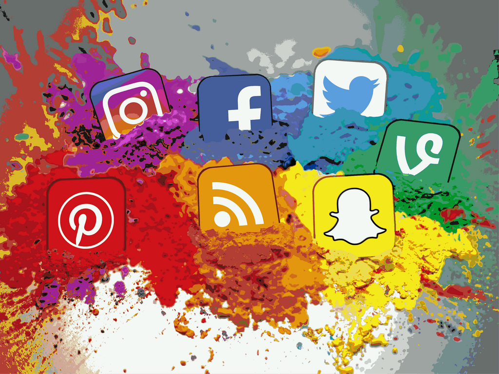 7 social channel icons in a rainbow of colours with exploding paint. Illustration.